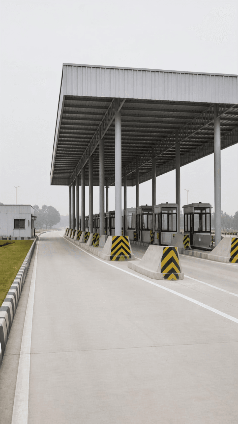A toll plaza canopy on repeating columns with empty lanes receding into haze.