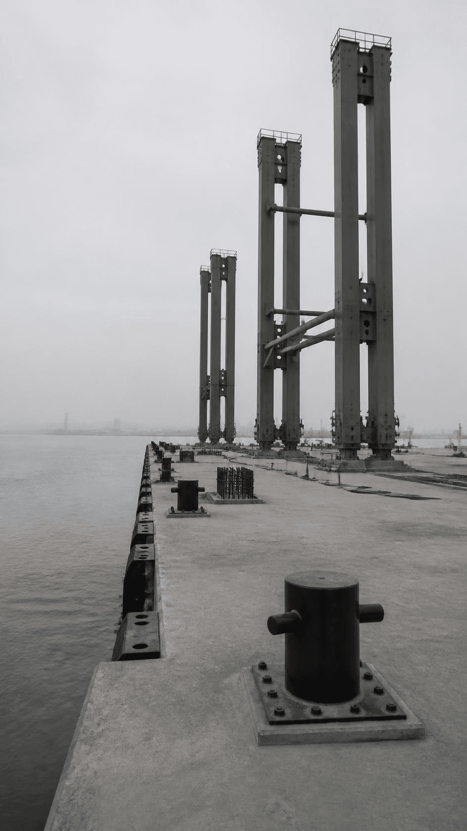 A container quay under construction, crane legs partly erected on a new concrete deck.