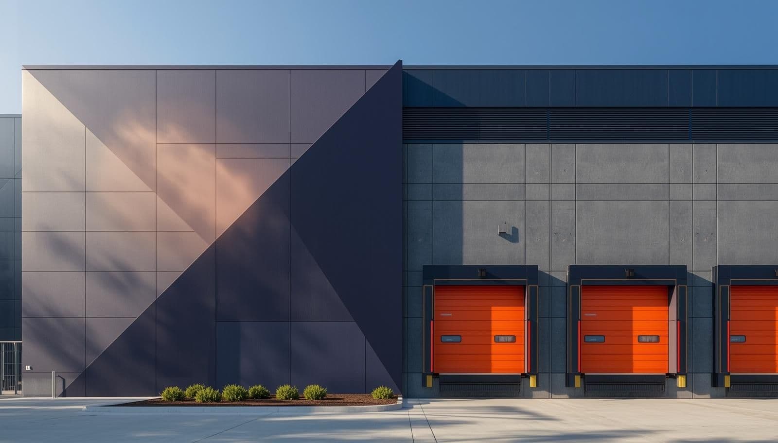 A high-resolution, architectural close-up of a Grade-A logistics park exterior. The building features a sleek, modern facade made of dark blue and grey geometric panels, contrasted by bright, highly visible orange loading dock doors, signalling premium, compliance-ready infrastructure.